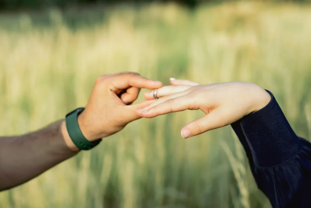 Couple exchanging a ring during a romantic moment outdoors