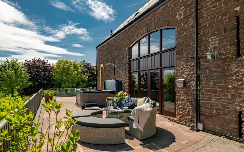 Patio with day bed, hot tub and outdoor shower, Penblaith Barn