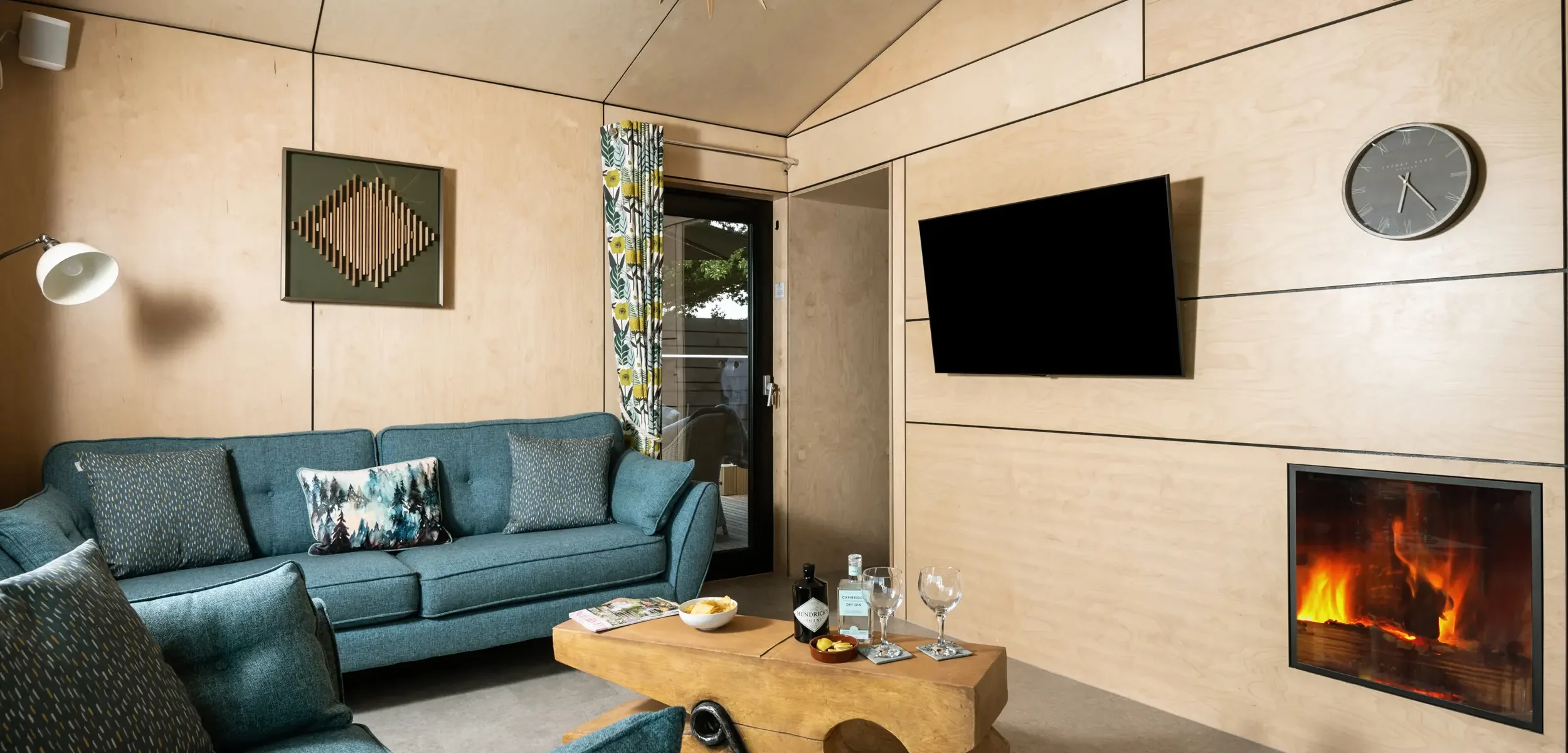 Relaxing living area with comfortable seating, electric log-effect fire and Smart TV at Kestrel Retreat