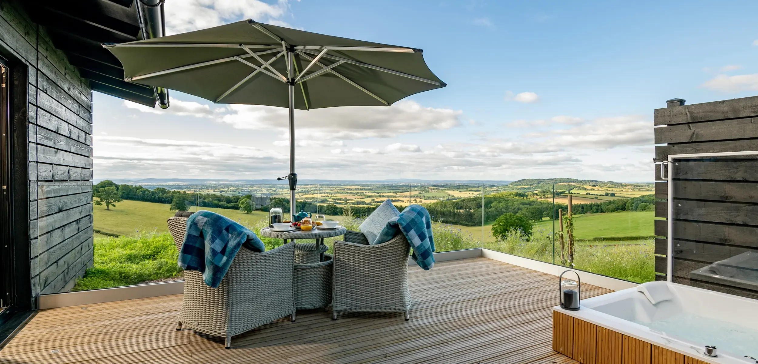 Private decking featuring alfresco dining and a double spa bath with stunning views across multiple counties at Kestrel Retreat