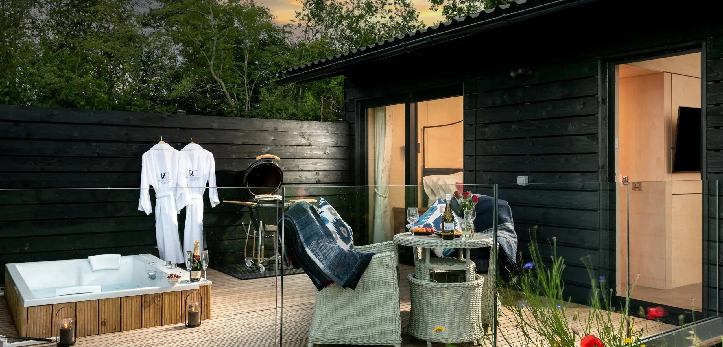 View onto the decking at dusk with outdoor dining, spa bath, bathrobes and ceramic charcoal BBQ, Barn Owl Retreat