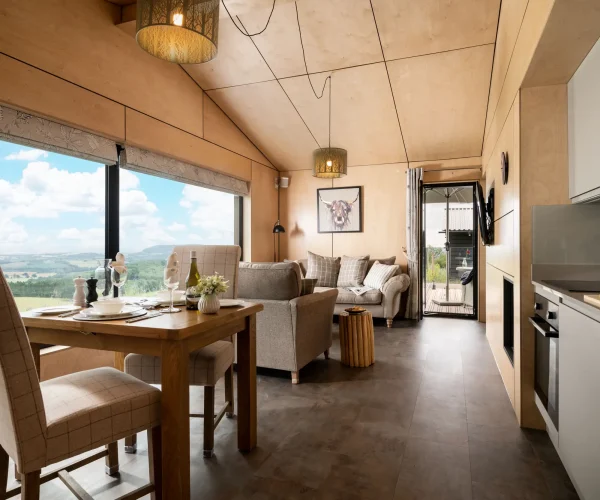 Open-plan kitchen, dining and sitting area at Barn Owl Retreat with stunning views across multiple counties
