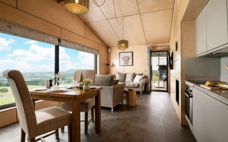 Open-plan kitchen, dining and sitting area at Barn Owl Retreat with stunning views across multiple counties