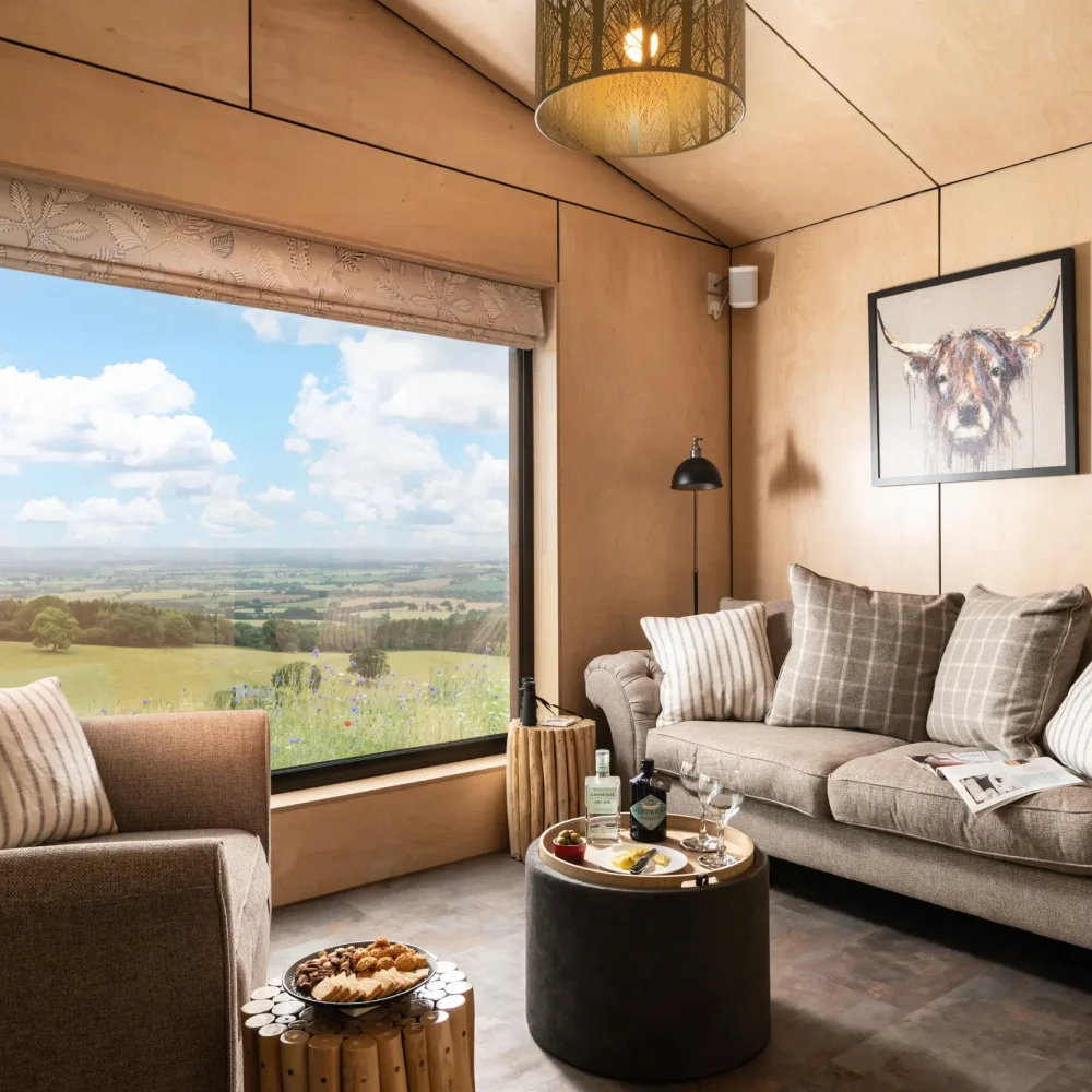 Cosy sitting room at Barn Owl Retreat with comfortable seating and stunning countryside views