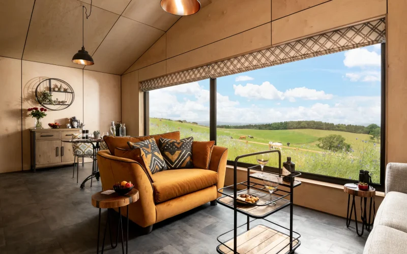 Open-plan seating and dining area with stunning countryside views at Peregrine Retreat